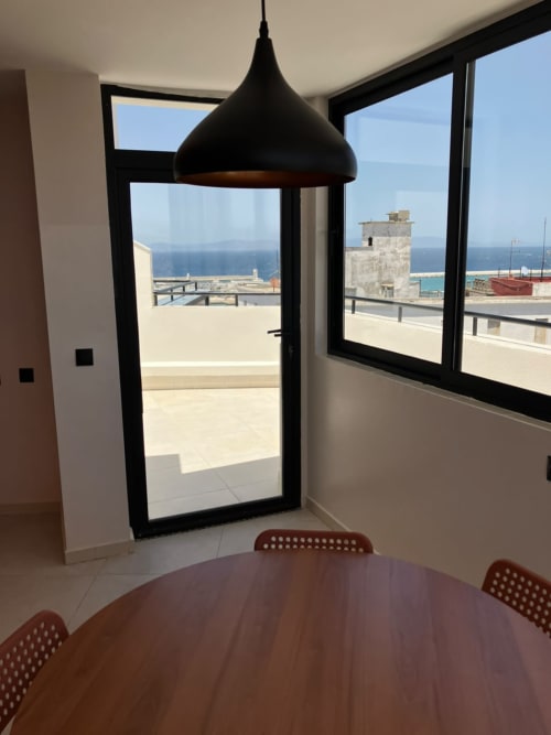 Modern dining room with panoramic sea views overlooking Tangier, Morocco from YaYaCaSa Ocre apartment at SAMYAflat hotel
