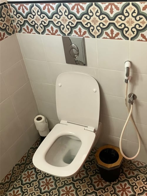 Modern white toilet with bidet in SAMYAflat apartment bathroom, Tangier, featuring decorative Moroccan tile patterns