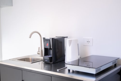 Angolo cottura moderno nell'appartamento Newhouse Modugno con lavello, rubinetto, macchina da caffè e elettrodomestici bianchi