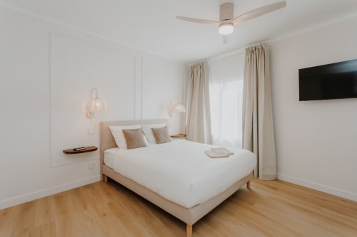 Chambre lumineuse et contemporaine à la Villa des Fleurs avec lit beige, parquet et vue sur la ville à Blonville-sur-Mer