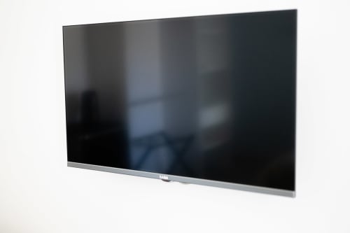 TV moderno a schermo piatto montato a parete nella camera Francy 3 dell'hotel Newhouse, Bari