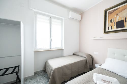 Camera Francy 3 al Newhouse hotel di Bari con due letti singoli, finestra, aria condizionata e quadri alle pareti