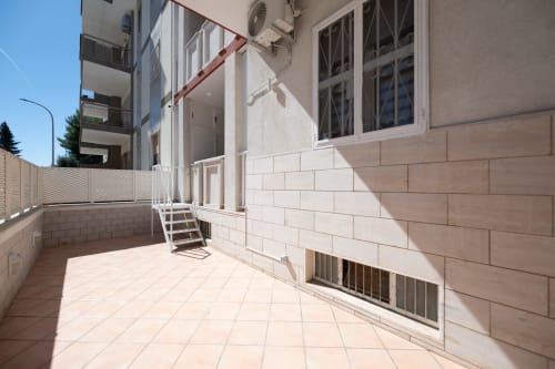 Soleggiato patio esterno della camera Francy 2 presso l'hotel Newhouse a Bari, con terrazza piastrellata e scale bianche