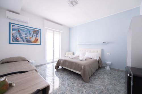 Camera Francy 2 presso l'hotel Newhouse a Bari - elegante camera da letto con letto matrimoniale, TV e arredamento minimalista luminoso
