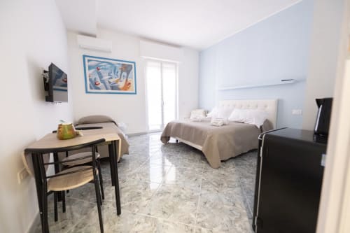 Camera Francy 2 moderna dell'hotel Newhouse Bari con letto, scrivania, TV, minibar e pavimento in marmo