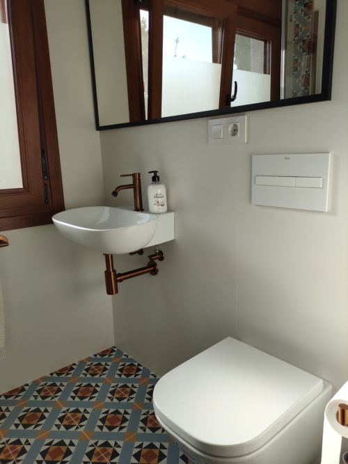 Modern bathroom at Vacationgalicia in Pantón with white sink, vessel basin, copper fixtures, and geometric floor tiles