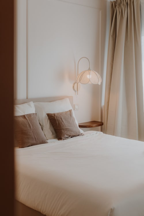 Chambre élégante à la Villa des Fleurs à Blonville-sur-Mer avec literie blanche, oreillers beige et lampadaire en arche
