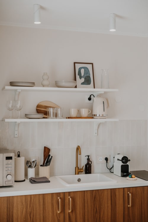 Cuisine minimaliste à la Villa des Fleurs avec étagères blanches, meubles en bois et appareils modernes