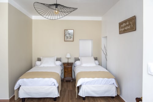 Deux lits jumeaux aux draps blancs à La Suite, La Demeure du Comte B&B, Marcillac-Vallon, avec vue jardin et décor moderne