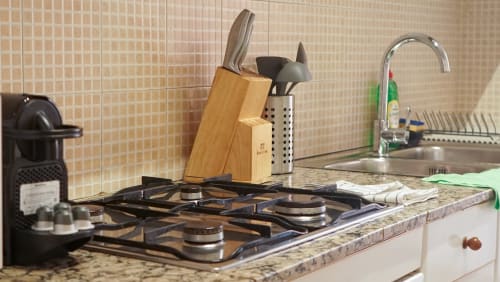 Cocina de apartamento Barcelona BCNMADflats con estufa a gas, bloque de cuchillos y fregadero con grifo en encimera de granito