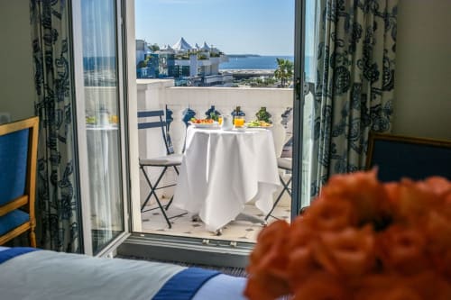 Terrasse de l'Hôtel Splendid Cannes avec vue sur la Méditerranée et tables élégantes au service blanc