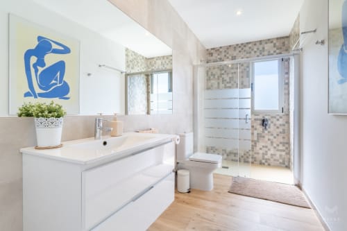 Baño moderno en villa Can Colomer Ferragut cerca de Artà con tocador blanco, ducha a ras de suelo y acabados contemporáneos
