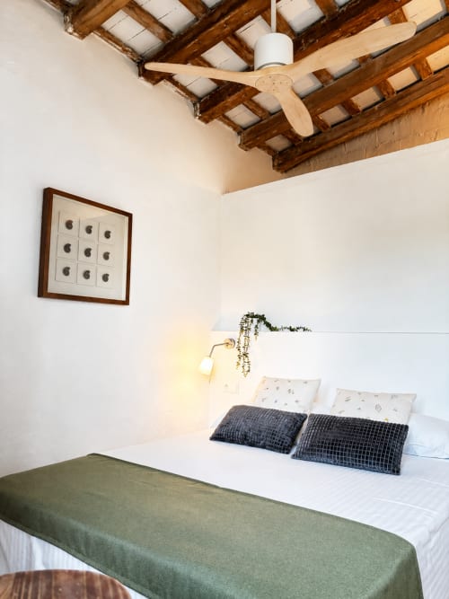 Habitació acollidora al Mas Ribas Hotel de Palamós amb bigues de fusta, ventilador de sostre i vistes al jardí