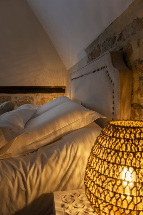Chambre douillette La Bohème à La Demeure du Comte, Marcillac-Vallon, avec éclairage chaleureux, oreillers blancs et lampe décorée