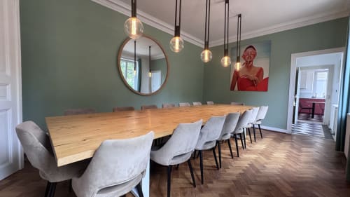 Salle à manger contemporaine à la Villa Avril & Spa de Sélestat avec table en bois massif, chaises grises et luminaires suspendus