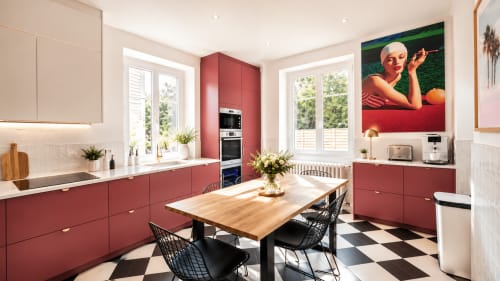 Cuisine moderne à Villa Avril & Spa à Sélestat avec mobilier rouge, table en bois et chaises noires baignées de lumière naturelle