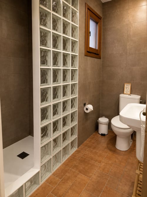 Modern bathroom with glass block shower partition and terracotta tiles at Mas Ribas Hotel in Palamos