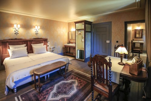 Chambre élégante à La Maison Oubliée à Goetzenbruck avec lit boisé, mobilier d'époque et éclairage ambiant chaleureux