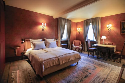 Chambre luxueuse aux décors rouge et or à La Maison Oubliée, Goetzenbruck, avec lit élégant et mobilier classique