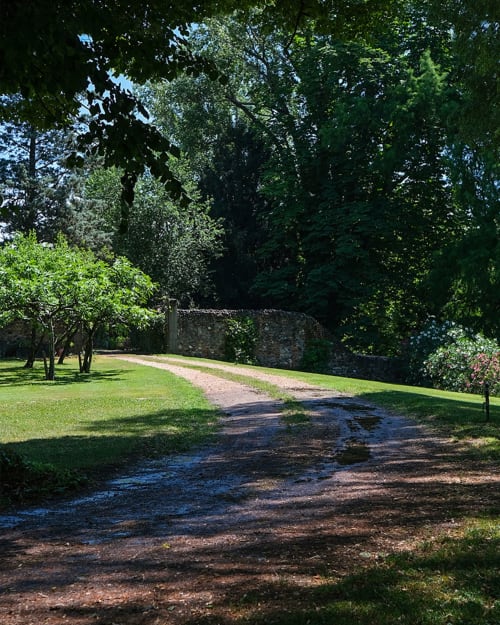 Viale alberato della Corte Pellegrini B&B di Verona, con muri in pietra e splendidi giardini verdeggianti