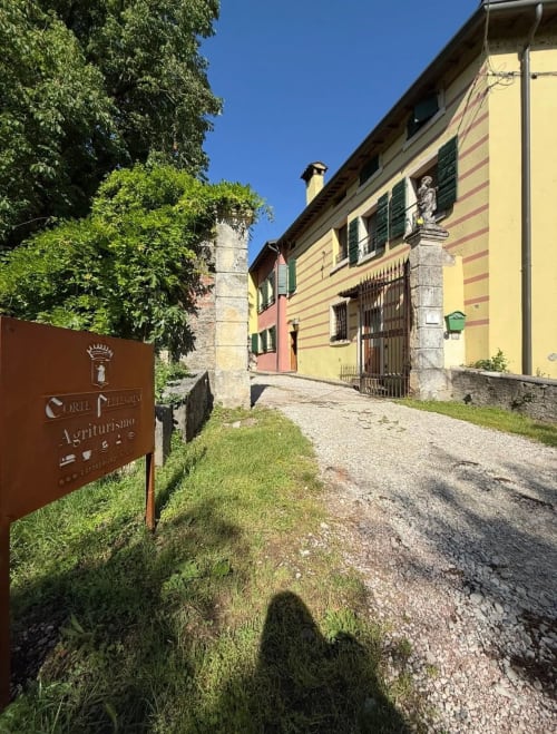 Ingresso della Corte Pellegrini B&B a San Martino Buon Albergo, Verona, con villa gialla e torre ricoperta di edera