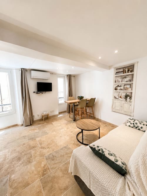 Modern studio apartment in Hyères with bed, dining table, TV, kitchenette and builtin shelving