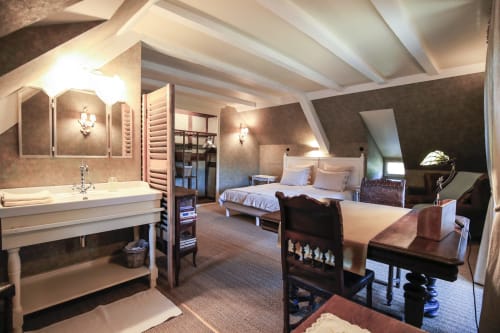 Spacieuse chambre mansardée à La Maison Oubliée avec poutres apparentes, lavabo, lit queen, bureau et vue sur le jardin