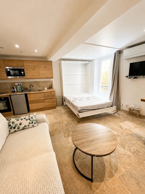 Studio moderne à Hyères avec cuisine en bois, lit escamotable, séjour et balcon vue sur la ville