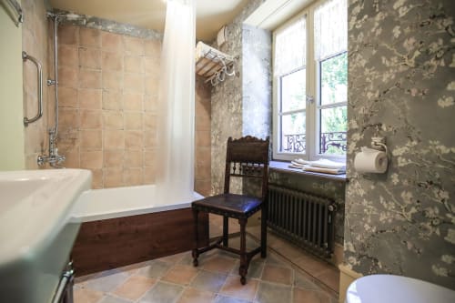Salle de bain à la maison oubliée B&B à Goetzenbruck avec baignoire, douche, chaise vintage et papier peint décollé