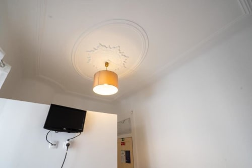 Luminária de teto com medalhão de gesso decorativo no quarto do hotel Madeirarooms, Funchal