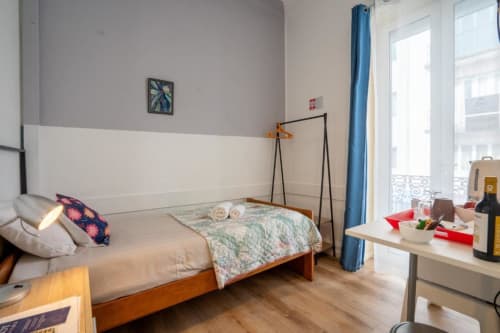 Quarto de cama de casal moderno em Madeirarooms Funchal com cama de madeira, varanda com vista para a cidade e decoração contemporânea