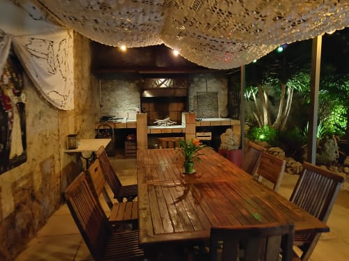 Terrasse de restauration en plein air aux Villas Lux Tropical avec table en bois, chaises, guirlandes lumineuses décoratives et vue sur le jardin