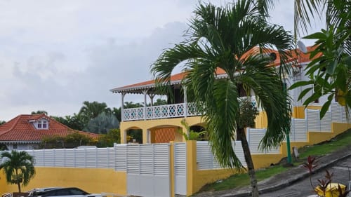 Villa jaune avec balcon blanc et palmiers, Villa La Suite Viva Vero, propriété tropicale caribéenne avec vue sur la piscine