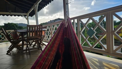 Hamac violet sur terrasse couverte avec balustre en bois, table à manger et vues sur les montagnes à Villa La Suite Viva Vero