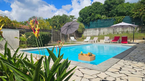 Sublime piscine bleue scintillante à la Villa La Suite Viva Vero avec chaises longues, parasols, fleurs tropicales et jardins luxuriants