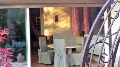 Salle à manger élégante avec table ronde et housses de chaise blanches aux Villas Lux Tropical, vue à travers les portes vitrées sur le jardin