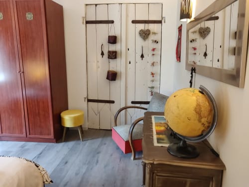 Intérieur de villa éclectique aux Villas Lux Tropical avec globe jaune, meuble rouge, panneaux blancs déccoratifs et mobilier d'époque