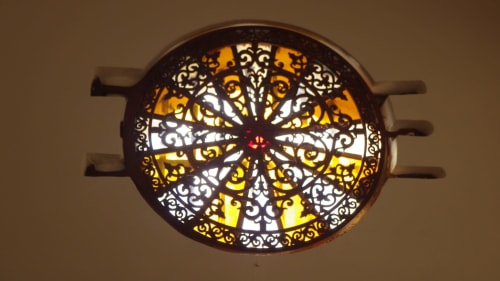 Élégant luminaire de plafond orné aux motifs géométriques jaunes et blancs dans la chapelle-villa restaurée du XVIIIe siècle