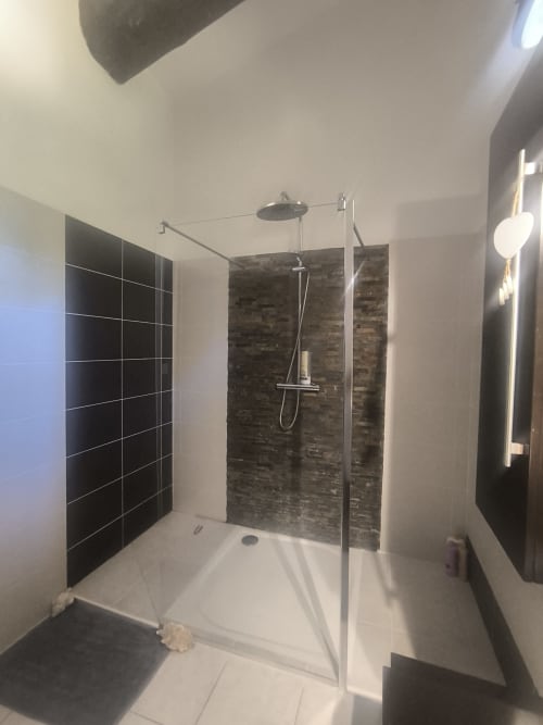 Salle de bain moderne avec douche à l'italienne, carrelage noir, receveur blanc et douchette pluie à la villa Villas Lux Tropical