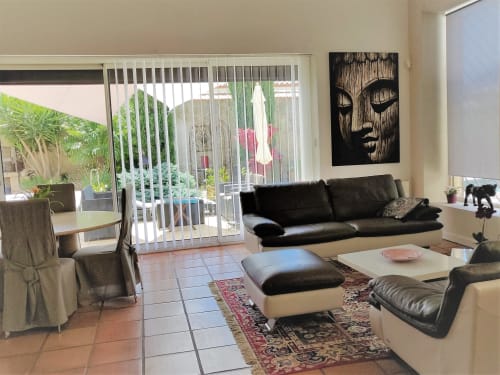 Salon luxueux de la villa Villas Lux Tropical Béziers avec canapé en cuir noir, vue sur la piscine et décoration moderne