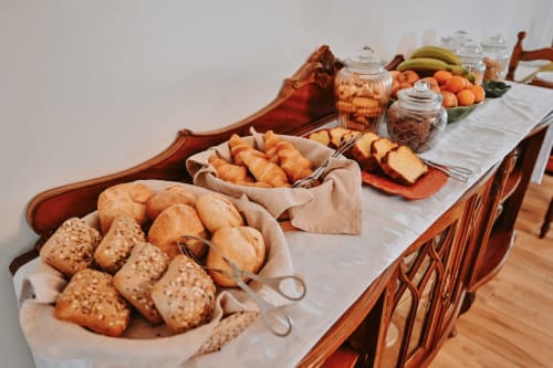 Breakfast spread at Casa de Campo da Quinta da Pegada in Óbidos with fresh breads, pastries, fruits, and beverages on wooden