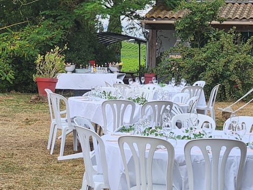 Réception en plein air au Domaine De Poulharies à Carcassonne avec tables blanches, décoration florale verte et élégante