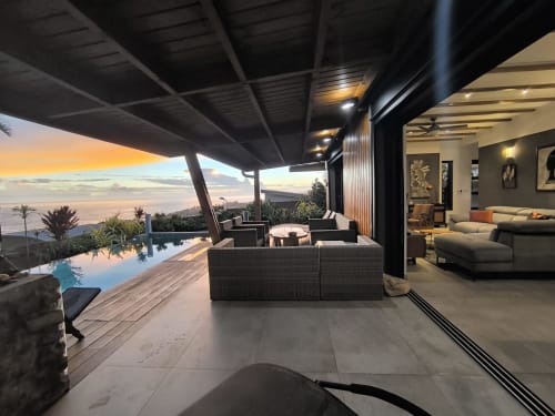 Terrasse de villa luxe au coucher de soleil avec piscine à débordement, vue océan, salon contemporain et espace intérieur à Saint-Pierre,