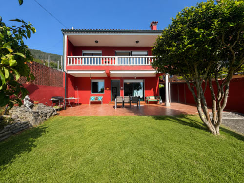 Casa de campo rojo brillante Vila Santa Rita con terraza, jardín y vista al mar en Oia, perfecta para escapada vacacional