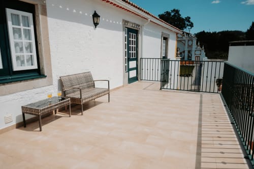 Sunny terrace at Casa de Campo da Quinta da Pegada in Óbidos with seating, white-washed walls and ocean views