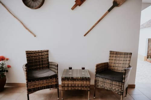 Rustic wicker seating area at Casa de Campo da Quinta da Pegada in Óbidos with two chairs and side table