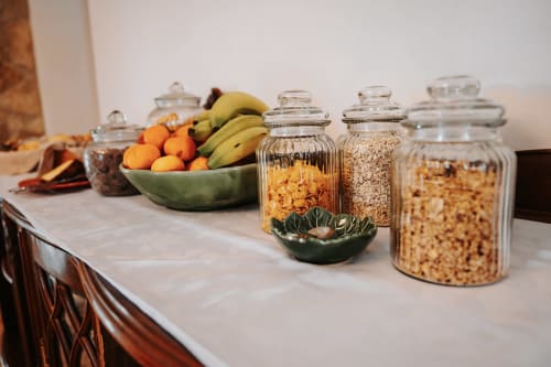 Kitchen counter at Casa de Campo da Quinta da Pegada displaying fresh fruits, bananas, and glass storage jars with cereals
