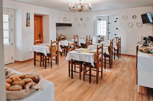Rustic dining room at Casa de Campo da Quinta da Pegada in Óbidos with wooden tables, white linens, and traditional