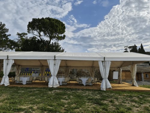 Grand chapiteau blanc pour événement au Domaine de Poulharies à Carcassonne avec tables et chaises dressées pour le repas