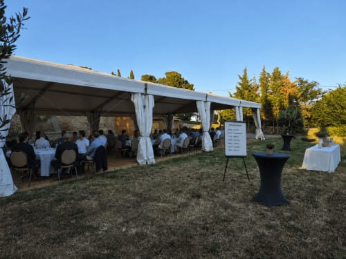 Installation de tente d'événement en plein air au Domaine De Poulharies à Carcassonne avec tables drapées blanches et invités
